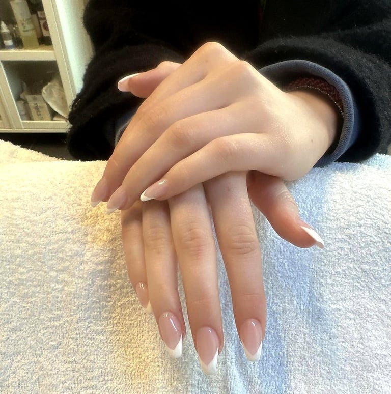 Hands stacked together showing off long almond-shaped nails with neutral ombre nail polish design